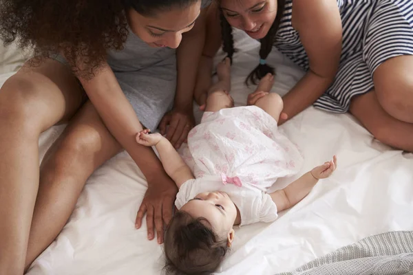 Anne ve kızının oynarken ile bebek yatakta — Stok fotoğraf