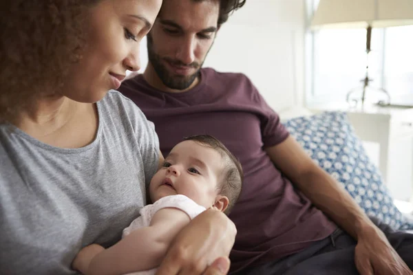 Pais sentados no sofá com bebê — Fotografia de Stock