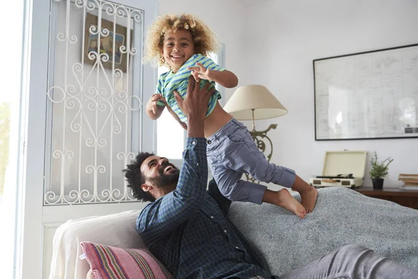 Hombre sosteniendo niño sobre la cabeza — Foto de Stock