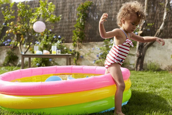 Flicka gå ur trädgården plaskdamm — Stockfoto