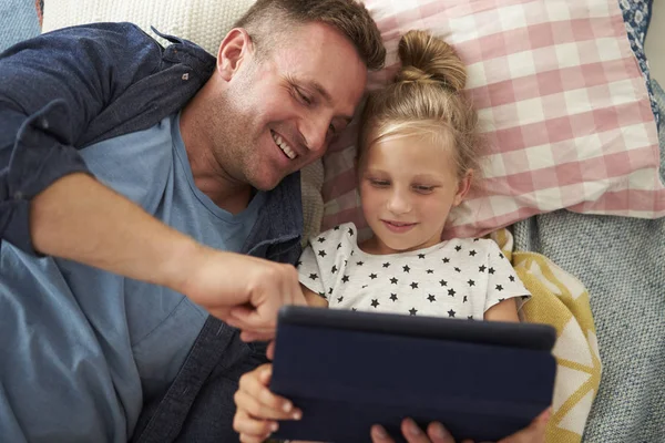 Vater und Tochter liegen mit digitalem Tablet — Stockfoto