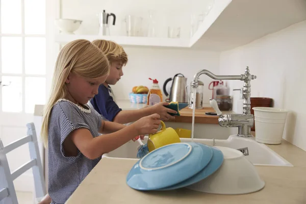 孩子们在厨房里洗盘子 — 图库照片