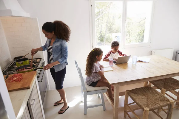 요리 하는 엄마와 주방에서 일 하는 아이 — 스톡 사진