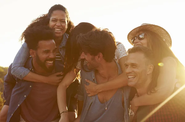 Couples piggybacking at sundown