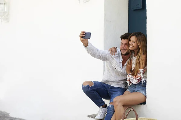Casal sentado e tomando selfie — Fotografia de Stock