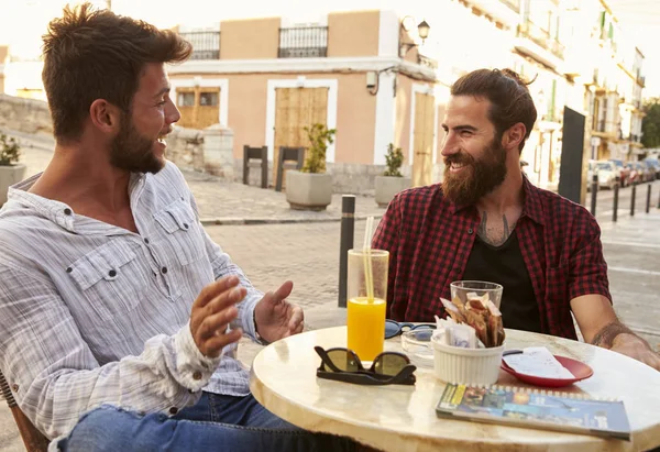 Männliche Freunde reden am Tisch — Stockfoto