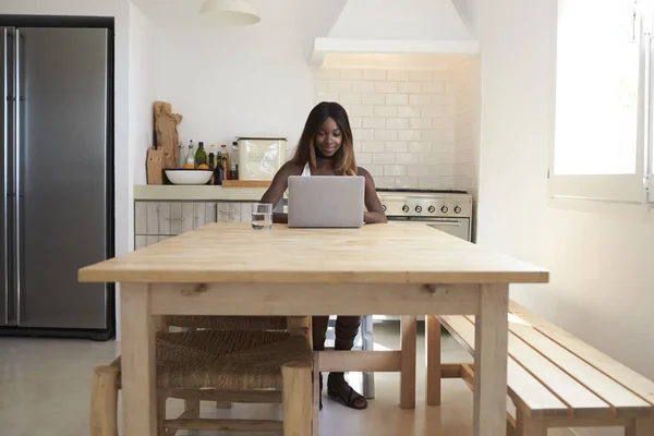 Жінка використовує ноутбук на кухні — стокове фото