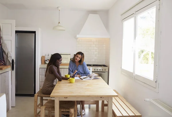 Mujeres jóvenes usando tableta y lectura —  Fotos de Stock