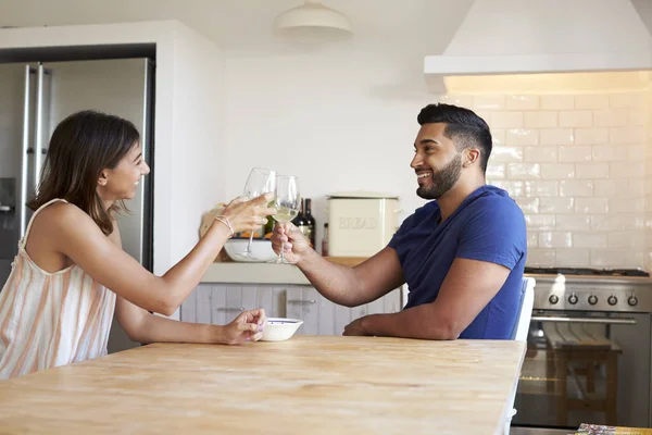 Молодая пара сидит и пьет вино — стоковое фото