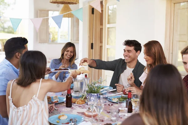 Amigos adultos comendo e bebendo na festa — Fotografia de Stock