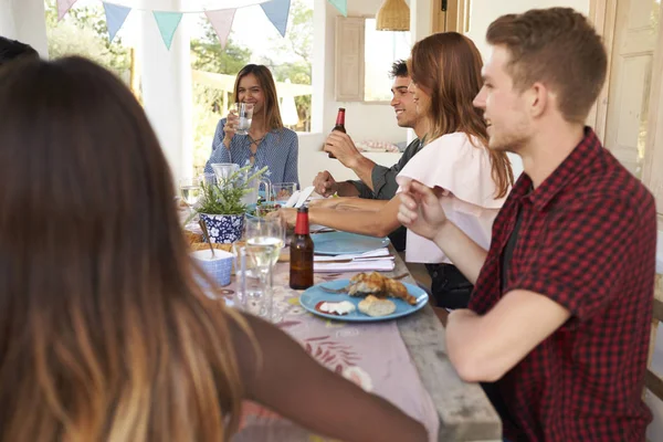 Amici adulti che mangiano e bevono alla festa — Foto Stock