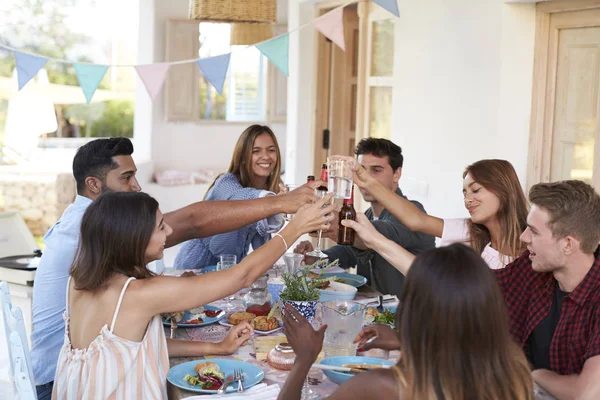 Freunde stoßen bei Dinnerparty an — Stockfoto