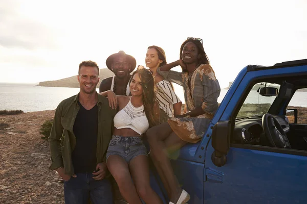 Jóvenes amigos de pie en coche — Foto de Stock