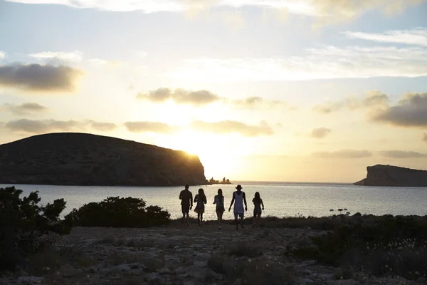 Friends standing on cliff watching sunset — Stock Photo, Image