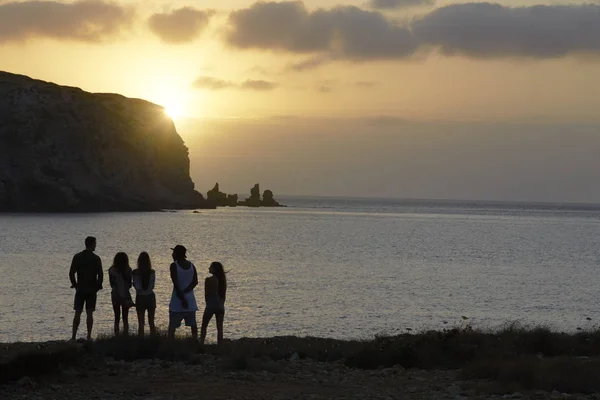 Friends standing on cliff watching sunset — Stock Photo, Image