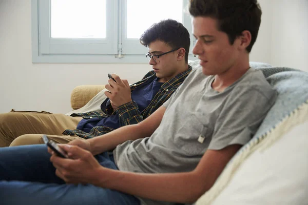 Хлопчики обмінюються повідомленнями зі смартфонами — стокове фото