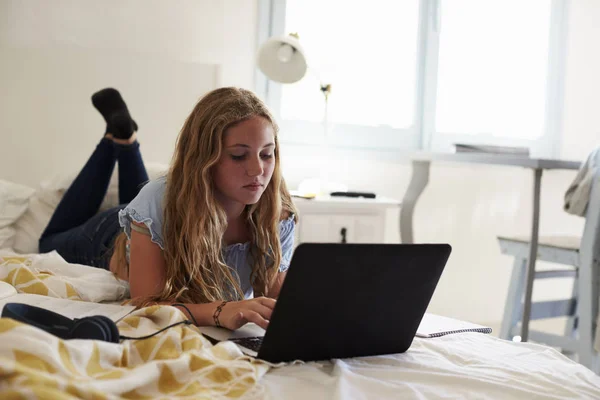 Teenager-Mädchen benutzt Laptop und lügt — Stockfoto