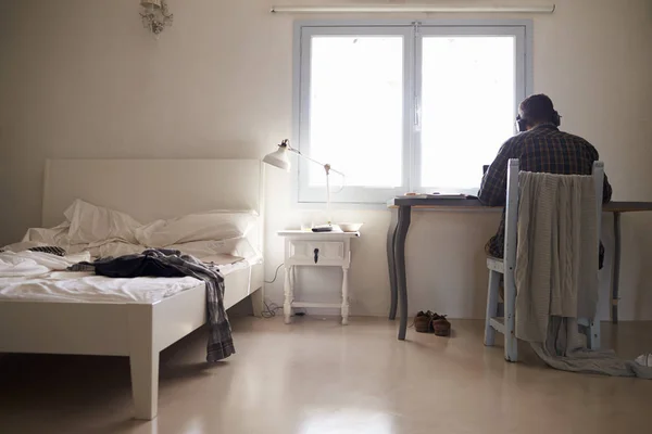 Jongen in hoofdtelefoons aan balie — Stockfoto