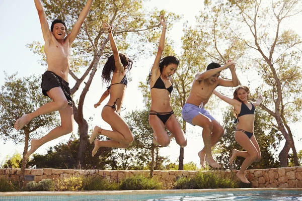 Fem tonåringar hoppning med upphöjda händer — Stockfoto