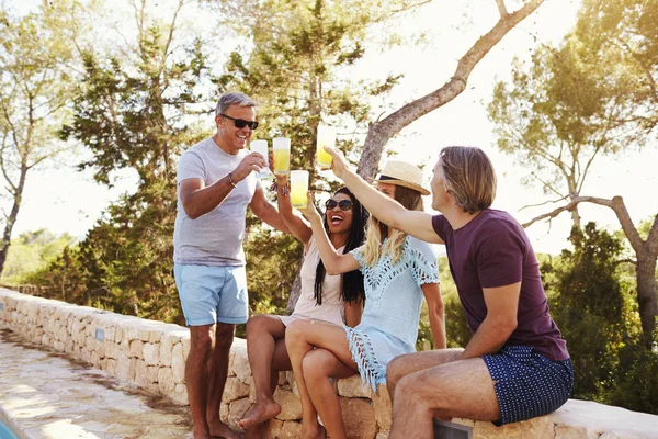 En man stående, andra personer som sitter nära pool — Stockfoto