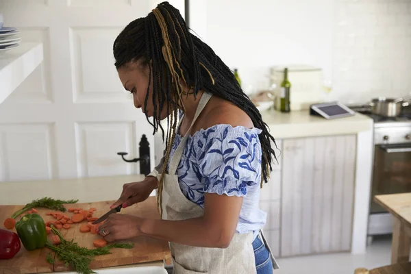 Mulher de pé na cozinha cortando legumes — Fotografia de Stock