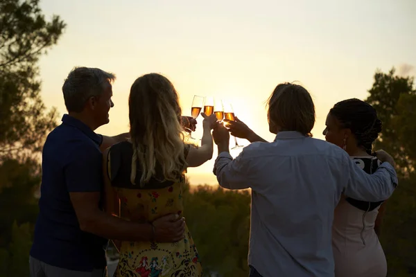 Parejas haciendo tostadas al atardecer — Foto de Stock