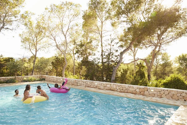 Jonge vrienden plezier in zwembad — Stockfoto