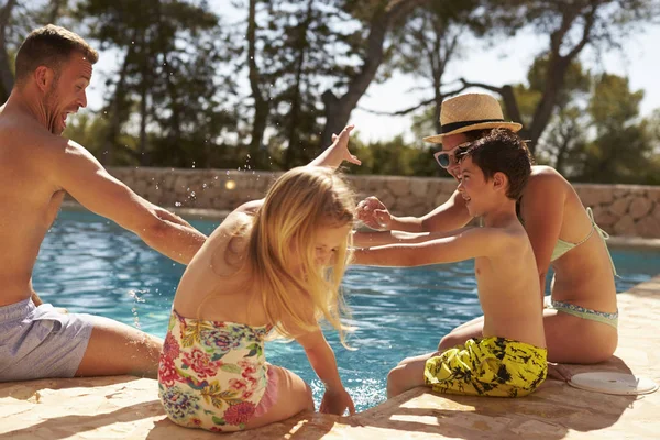 Familia divirtiéndose junto a la piscina — Foto de Stock
