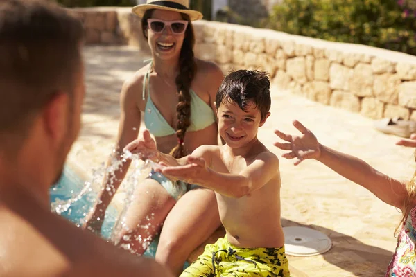 Família se divertindo à beira da piscina — Fotografia de Stock