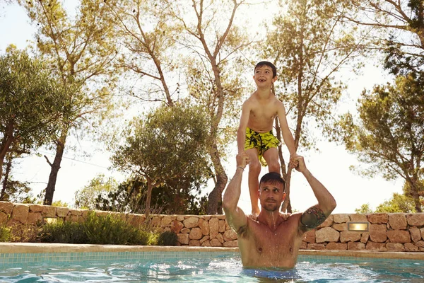 Son jumping from fathers shoulders — Stock Photo, Image