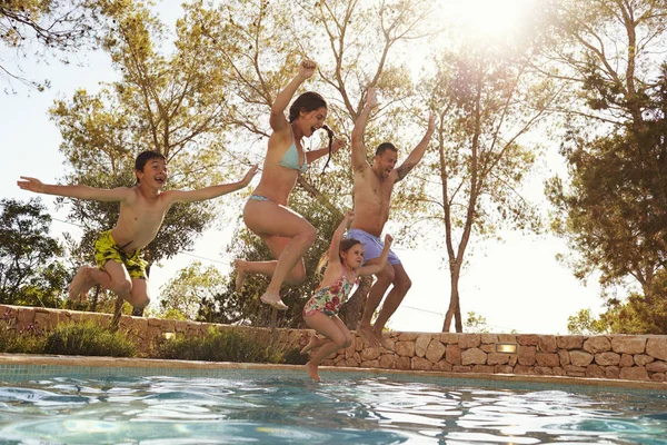 Familia saltando en la piscina — Foto de Stock