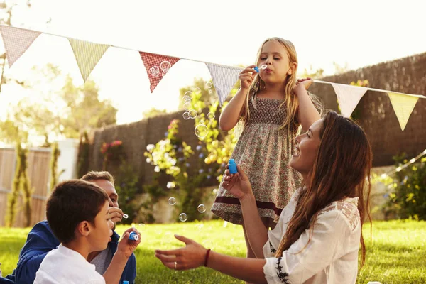 Padres soplando burbujas con niños — Foto de Stock