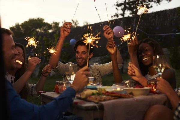 Friends with sparklers enjoying backyard party — Stock Photo, Image