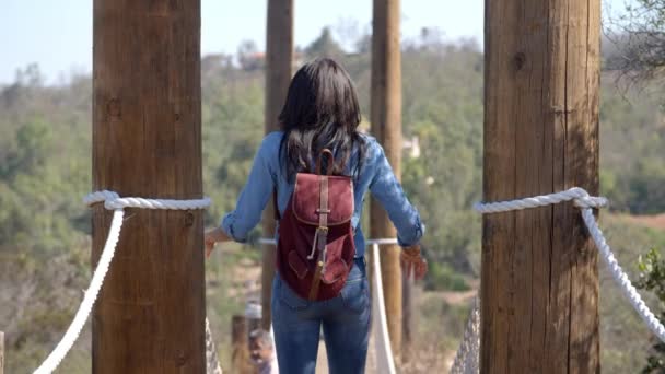 Женщина ходит по веревочному мосту — стоковое видео