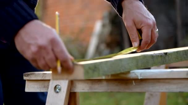 Зріла людина вимірювання і розпилювання деревини — стокове відео