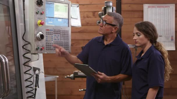 Инженер обучает ученика на станке с ЧПУ — стоковое видео