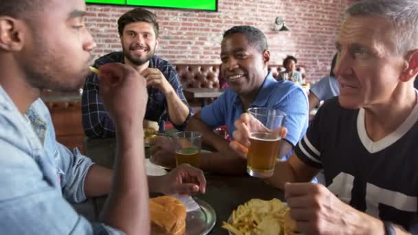 Друзья, питающиеся в спортивном баре — стоковое видео