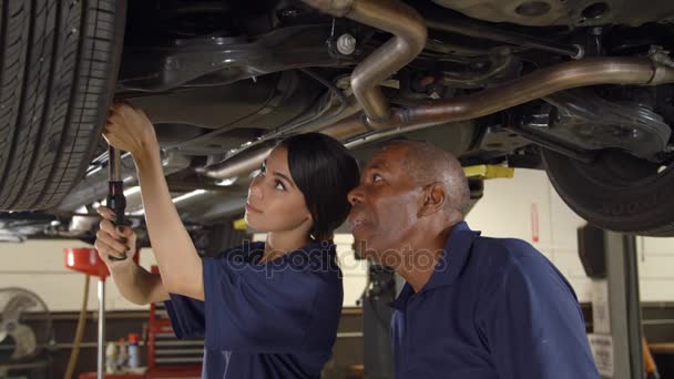 Estagiário mecânico trabalhando debaixo do carro — Vídeo de Stock