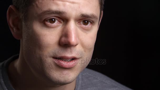 Tränenreicher Mann vor schwarzem Hintergrund — Stockvideo