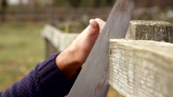 Mann fixiert Gartenzaun mit Säge — Stockvideo