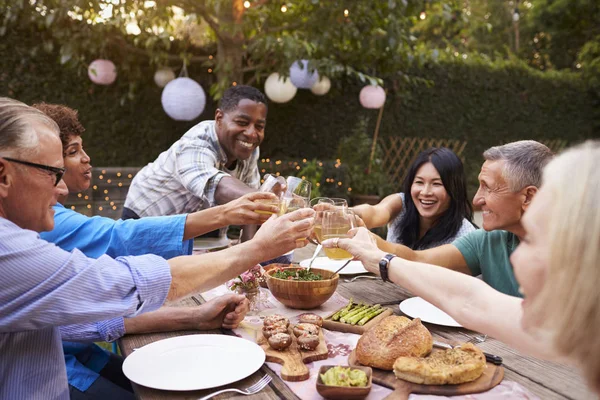 Amigos maduros disfrutando de la comida al aire libre — Foto de Stock