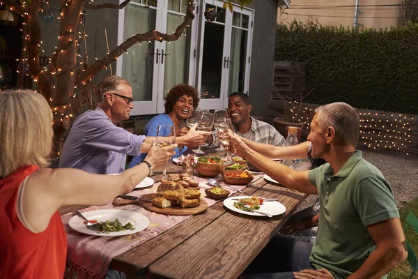 Amigos maduros disfrutando de la comida al aire libre — Foto de Stock