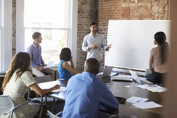 Businessman At Whiteboard In Brainstorming Meeting — Stock Photo, Image