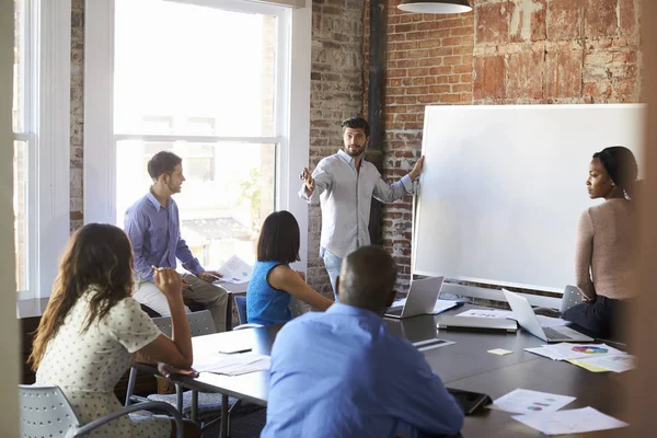 Empresario en pizarra en reunión de lluvia de ideas — Foto de Stock