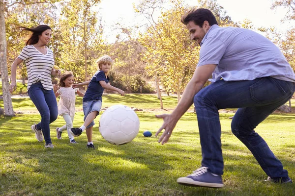 Семья играет в футбол — стоковое фото