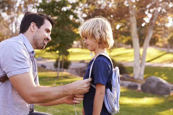 Vater schnallt Sohn den Rucksack an — Stockfoto