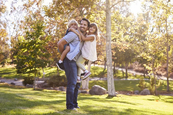 Pai carregando filho e filha — Fotografia de Stock