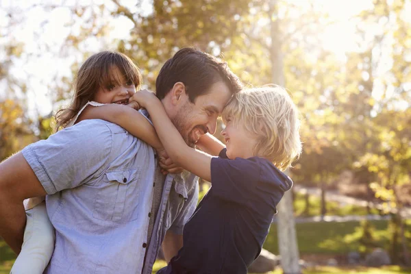 Pai carregando filho e filha — Fotografia de Stock