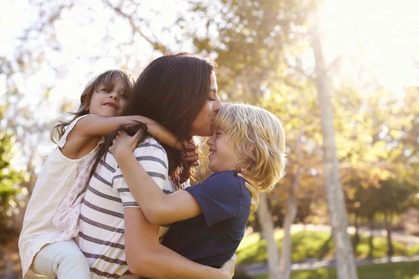 Mãe carregando filho e filha — Fotografia de Stock