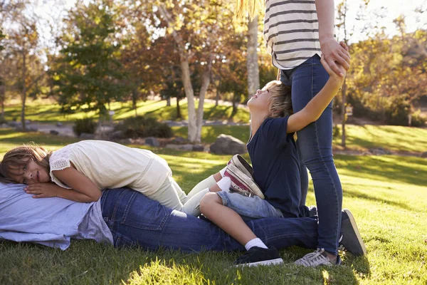 Mutter und Kinder liegen auf Vater — Stockfoto